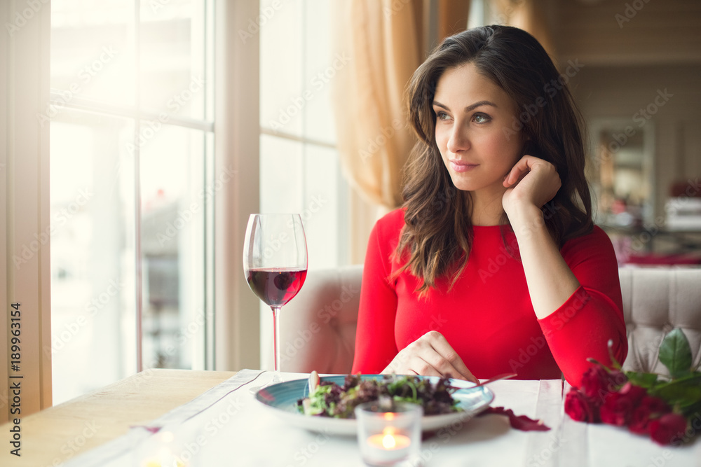Young woman sitting in the restaurant dining looking out the window Young woman sitting in the restaurant dining looking out the window