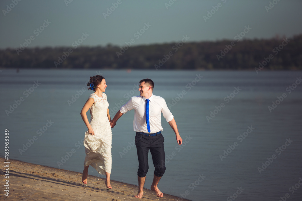 Sensual young happy couple celebrating their love on the beach and having fun. Toned image Sensual young happy couple celebrating their love on the beach and having fun. Toned image