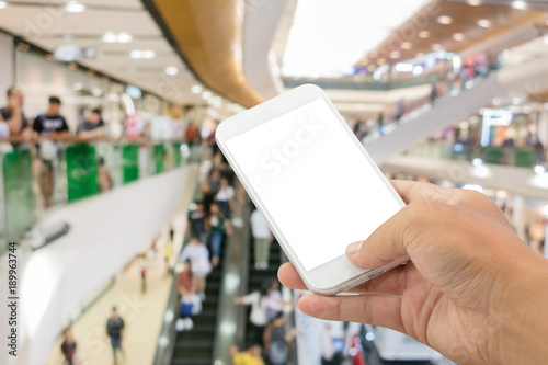 smartphone with abstract blur in shopping mall background.