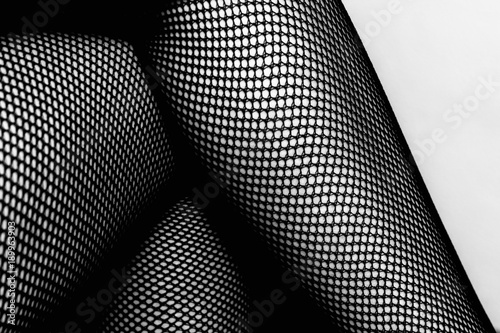 Black and white female legs in fishnet stockings