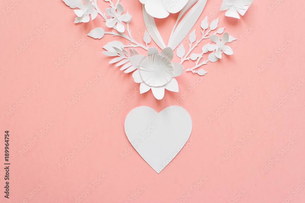 heart out of paper flowers cut from paper on pink background