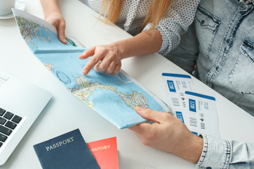 Young couple in a tour agency travelling concept choosing destination close-up