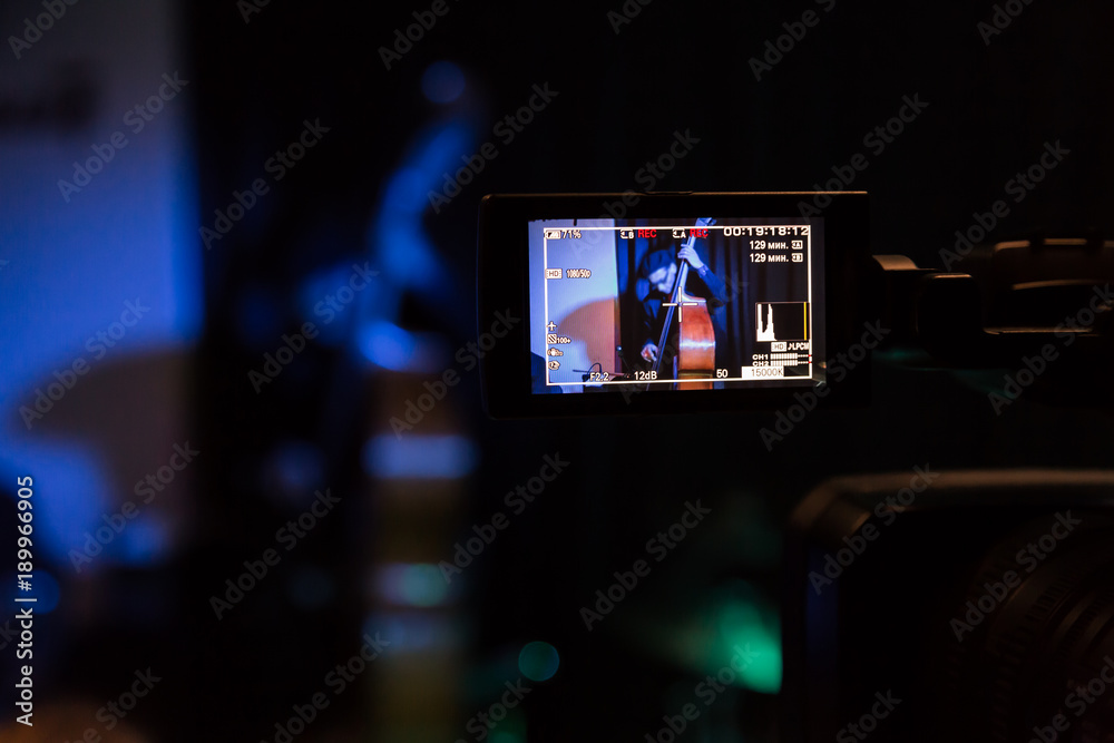 LCD display on the camcorder. Filming of the concert. The musician plays the double bass.