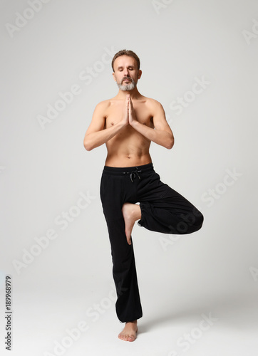 Old man practicing yoga doing stretching exercises © Dmitry Lobanov