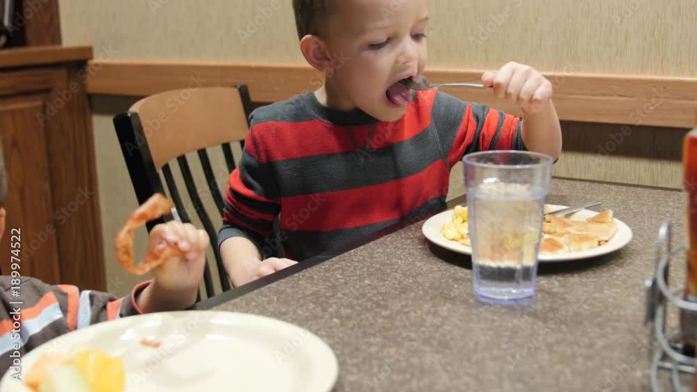 Dolly shot of cute little boys eating a continental breakfast Dolly shot of cute little boys eating a continental breakfast