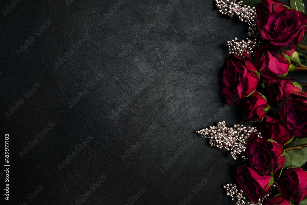 Obraz premium Burgundy or wine red roses and silver decor on dark background. True love passion and desire. Copy space concept