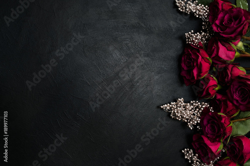 Fototapeta Naklejka Na Ścianę i Meble -  Burgundy or wine red roses and silver decor on dark background. True love passion and desire. Copy space concept