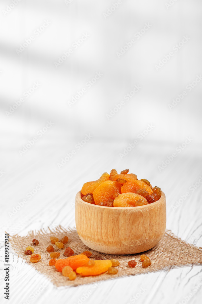 Useful delicious dried apricots and raisins in the bowl. The concept is healthy food, vegetarianism, diet, vitamins. Useful delicious dried apricots and raisins in the bowl. The concept is healthy food, vegetarianism, diet, vitamins.