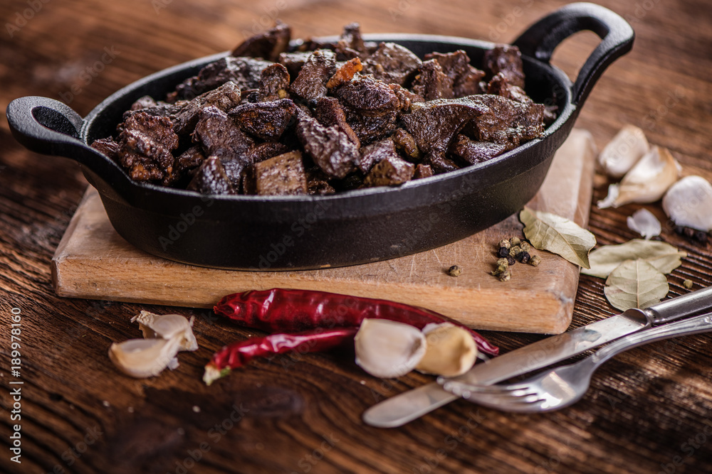 braised beef and lamb meat, liver, lungs and heart dish in black iron