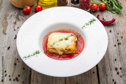Piece of tasty hot lasagna with red wine. Selective focus