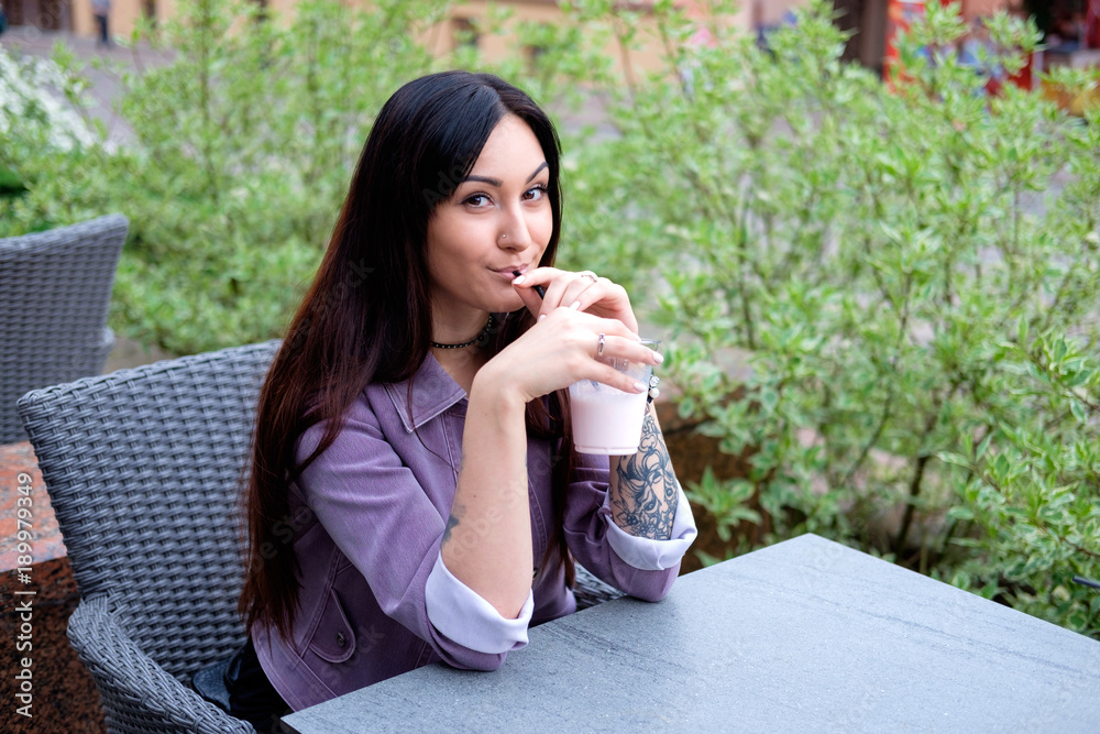 young pretty brunette woman drinking milky cocktail young pretty brunette woman drinking milky cocktail