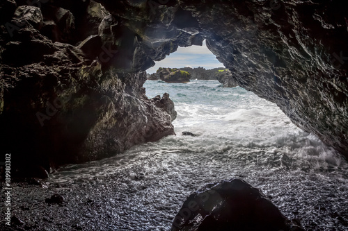 Die Brandung läuft in eine Höhle am Waianapanapa Black Sand Beach bei Hana auf Maui, Hawaii, USA. © DirkR