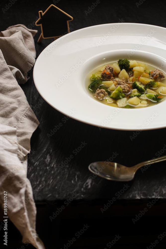 vegetable soup with meatballs and broccoli in a white plate vegetable soup with meatballs and broccoli in a white plate