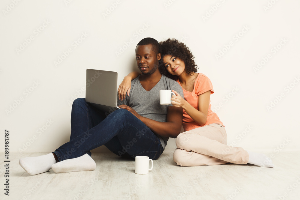 Happy african-american couple shopping online on laptop