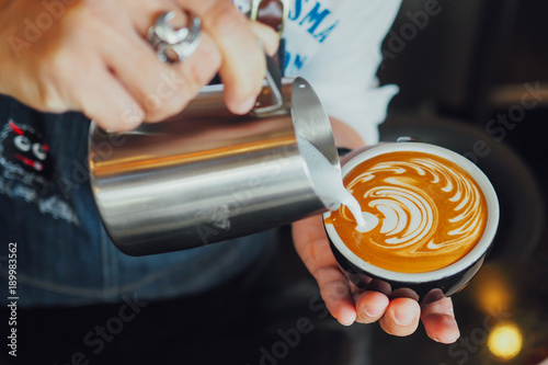 barista make coffee latte art with coffee espresso machine in coffee shop cafe in vintage color tone