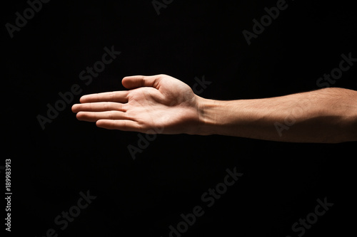 Hand ready for handshake isolated on black