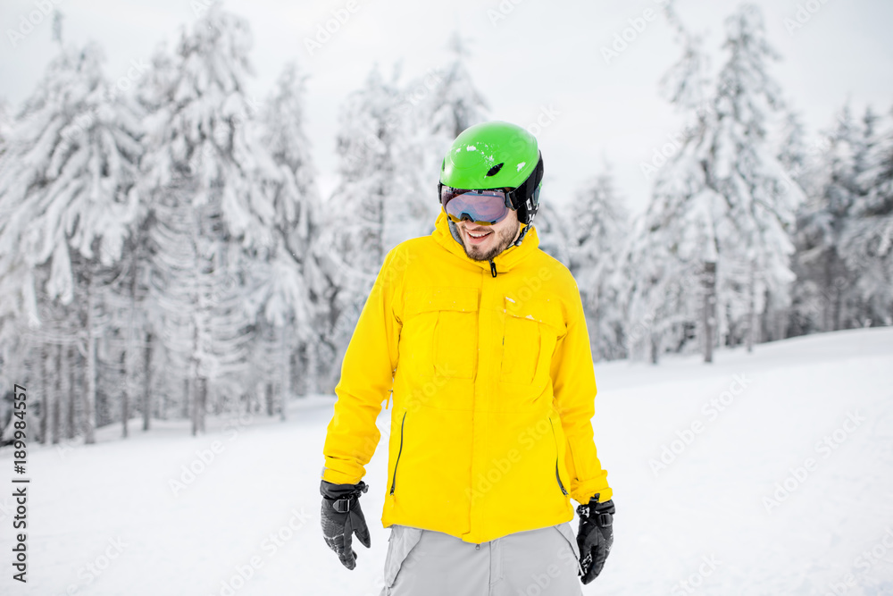 Portrait of a snowboarder in colorful winter sports clothes outdoors at the snowy mountains