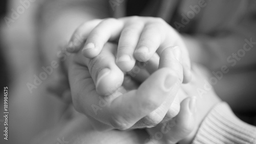 Mother's and a child hands, adult and children's hands, black and white photography photo