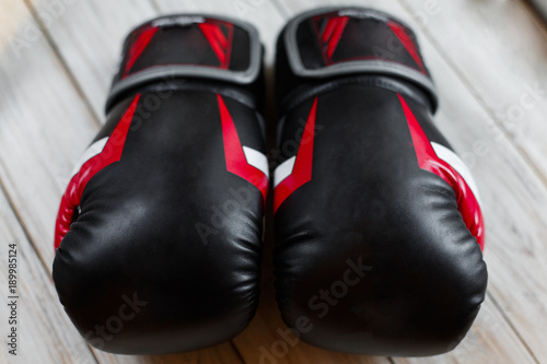 Pair of leather boxing gloves on wooden background. Sport equipment © beatleoff