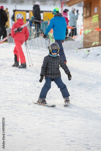 Small boy in ski mask and helmet learns skiing