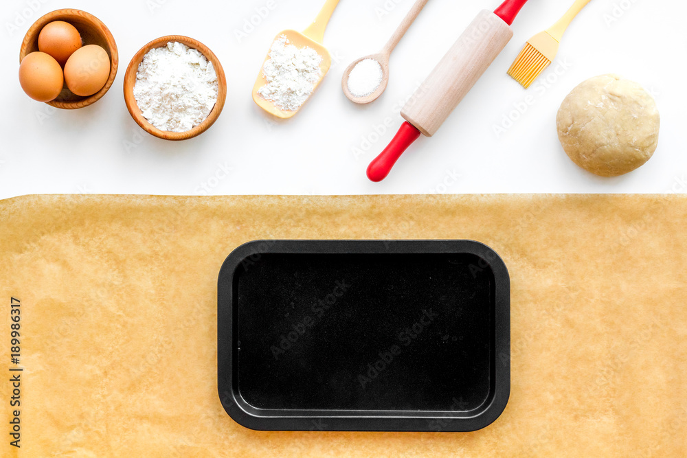 Prepare to baking. Dough ball near cookware on white background top view. Mock up with baking paper Prepare to baking. Dough ball near cookware on white background top view. Mock up with baking paper