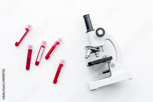 Blood test concept. Blood samples near microscope on white background top view