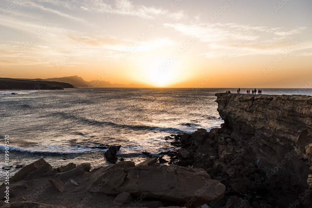 La Pared beach at sunset with people on top of the cliff in Fuerteventura, Canary Islands