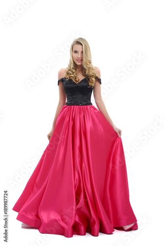 Wonderful girl wearing amazing long pink and black evening dress. Good choice for prom. Girl is very beatiful and has blonde curly hair, nice light make-up. Photo was taken on white studio background.