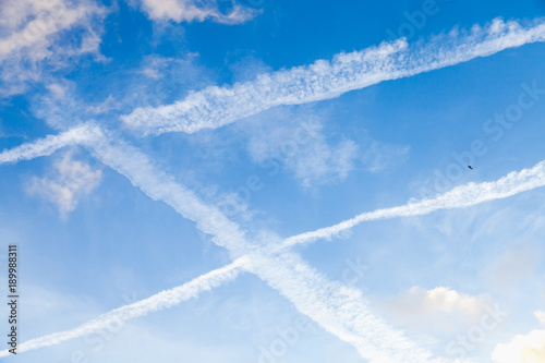 Blue sky with clouds and jet plane trails © evannovostro