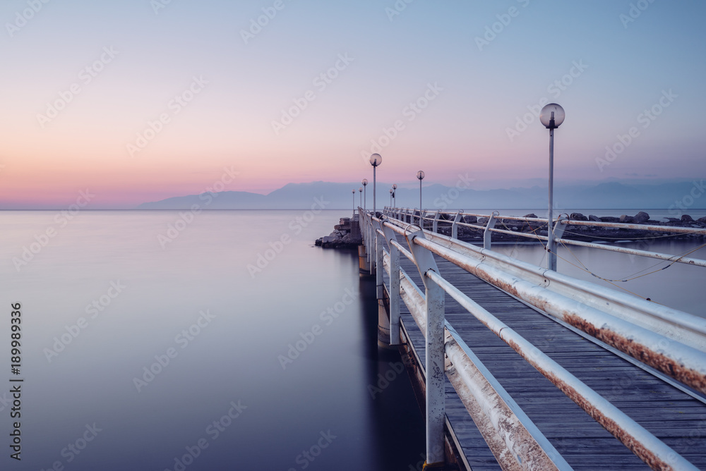 Wooden pier at dusk on Corfu island. Roda village. Greece.