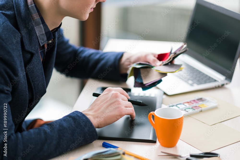 fashion designer sketching on graphic tablet. Creation of new clothes