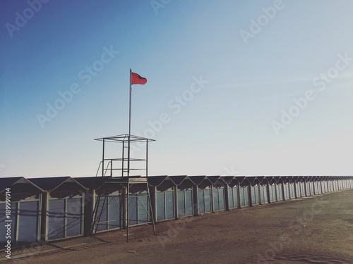 a red flag on a desert beach © Tatiana Zaghet
