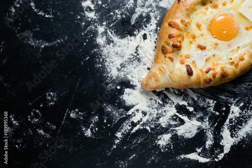 khachapuri adjara traditional Georgian cuisine meal. Baked bread with cheese and egg filling. National pastry snack. Free space concept photo