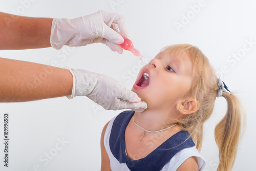 little girl on reception at the doctor receives the polio vaccine,
 photo
