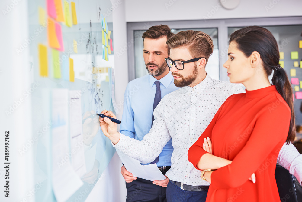 Obraz premium Three colleagues coworking during business meeting in office