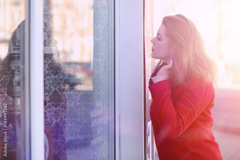 Pretty girl on a walk in red coat in the city Pretty girl on a walk in red coat in the city