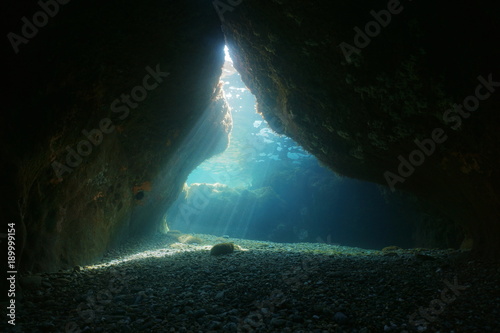 Exit of a cave underwater with natural sunbeams, Mediterranean sea, Pyrenees Orientales, Roussillon, France