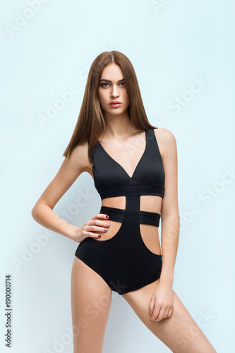 Young attractive woman in black swimsuit