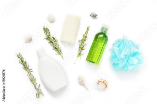 Flat lay natural organic bath products/ Shampoo bottle, soap bar, essential oil, rosemary herbs and blue bath sponge
