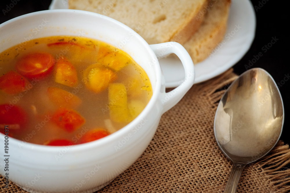 Fish soup with cherry tomatoes on a black textural background. Fish soup with cherry tomatoes on a black textural background.