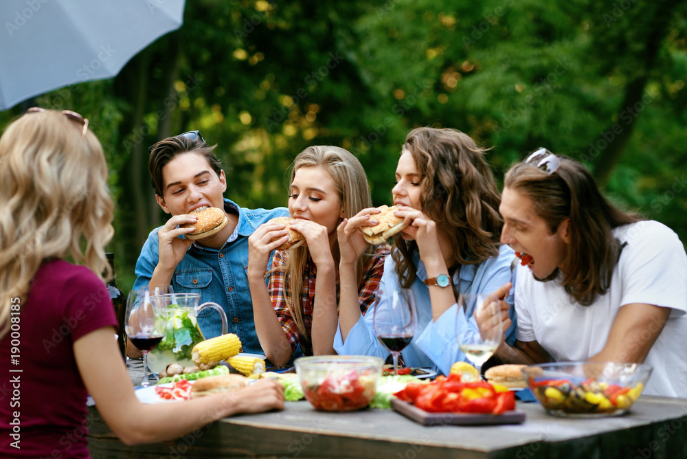 People Eating Healthy Food On Outdoor Party. Friends People Eating Healthy Food On Outdoor Party. Friends