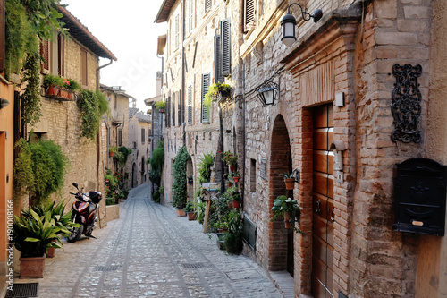 Fototapeta Naklejka Na Ścianę i Meble -  Traditional italian medieval alley in the historic center of beautiful little town of Spello, Perugia , in Umbria region - central Italy