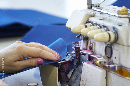 Closeup of a seamstress's work on an overlock in a sewing workshop. photo