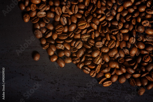 Coffee beans on a black textured background.