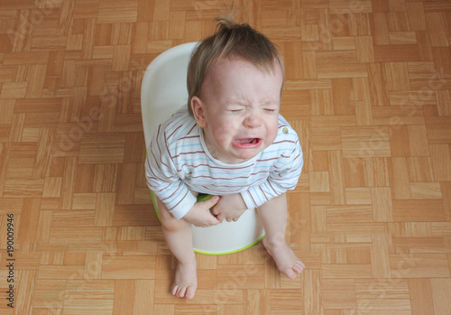 the child sits on a pot and cries. A little boy does not want to write to the pot. The child does not like to sit on the pot.