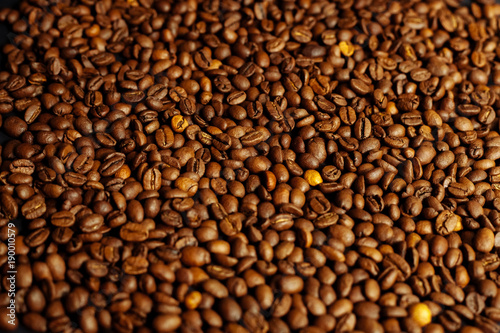 Coffee beans on a black textured background.