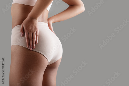 Close up of good looking female buttocks wearing high-waist panties. Copy space on right side. Isolated on background