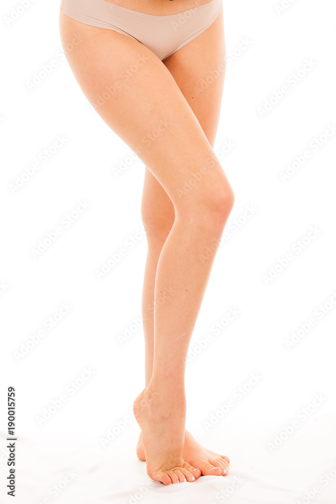 Long and slim woman legs standing over white background Long and slim woman legs standing over white background