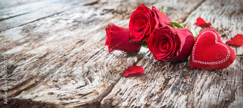 Red heart with roses on a rustic wooden background