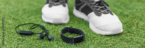 Sports watch and wearable tech wireless bluetooth earbuds to listen to music via smartwatch. Running accessories for runner, banner panorama. © Maridav